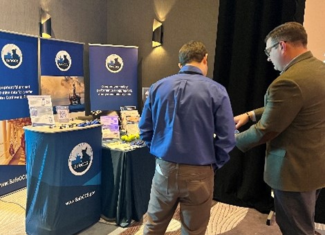 SafeOCS representative speaking with attendee at conference
